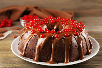 Fototapeta na wymiar Chocolate cake with snowball tree berries on a table