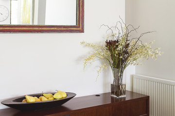 Fototapeta na wymiar Interior decorator items flowers buffet and mirror in luxury hom