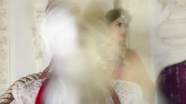 Shot of a Indian groom with bride standing in the background