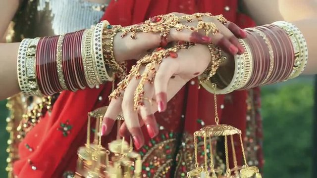 Shot of a Indian bride putting on bangles in her hand