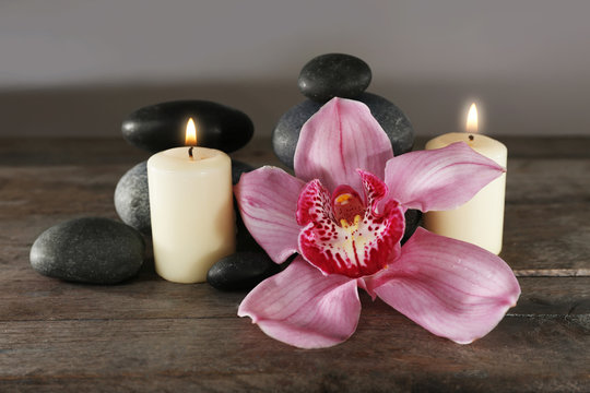Fototapeta Spa still life with beautiful flower and candlelight on wooden table closeup