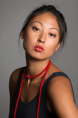 Young Asian woman with red beads.