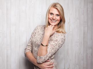 Fototapeta premium Blondine posiert vor Holzhintergrund