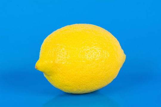 One ripe lemon on blue background