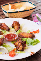 Fried chicken wings with ketchup.