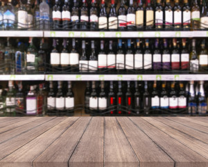 Wood table and wine Liquor bottle on shelf  Blurred background