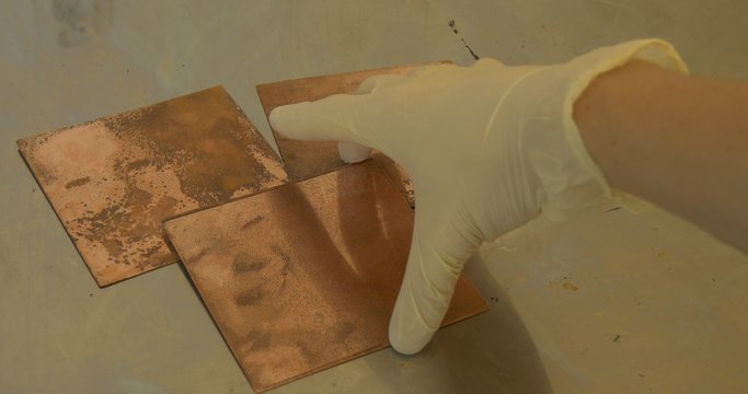 Man's Hands in Protective Gloves Are Holding The Copper Plates with Engraved Images of a Little Girl Process of Greating an Engraved Picture