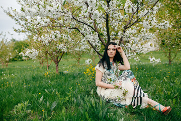 Spring walk girl in a beautiful cherry orchard