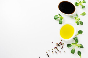 Healthy food background with olive oil, balsamic, cornsalad and colorful spices on white backdrop.Detox and diet concept. 