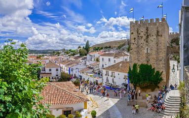 Obidos, Portugal. Cityscape of the town with medieval houses, wall and the Albarra tower. Obidos is...