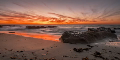 Zelfklevend Fotobehang Color My World-  Clouds turn brilliant orange, red and yellow as the sun sets over the Pacific Ocean splashing colors over clouds, water and sand. This is Bermuda Beach in San Diego, California. © MMPhotographyLLC
