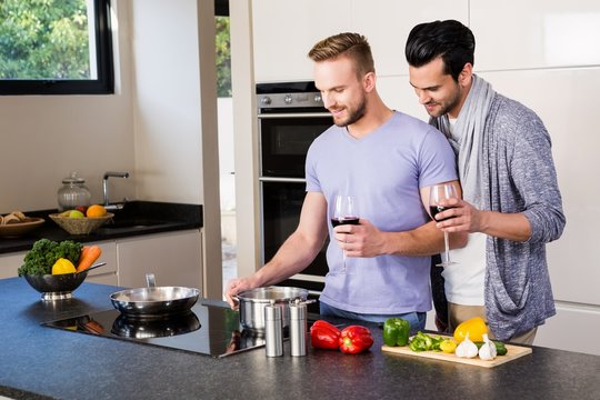 smiling gay couple preparing food 
