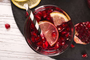 Pomegranate cocktail with lemon slices over wooden background. Top view. Selective focus