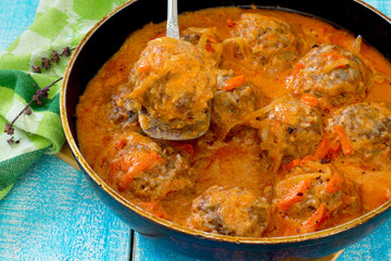 Homemade meatballs in tomato sauce with basil and spices in a fr