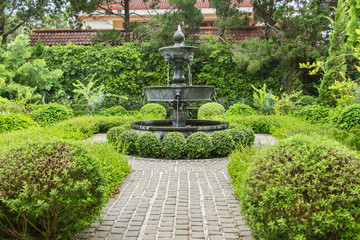 Nature background. Fountain in english garden design.