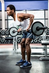 Fototapeta na wymiar Muscular man exercising with barebell