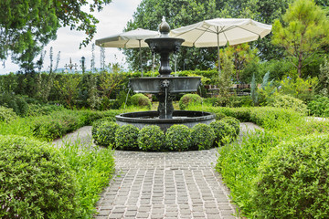 Nature background. Fountain in english garden design.