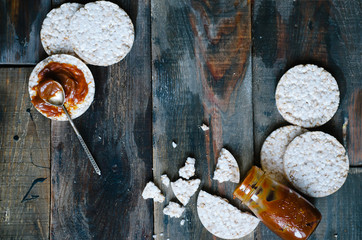 Fototapeta na wymiar Rice cakes with salted caramel on old wooden background