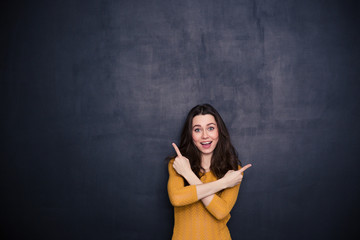 Cheerful young woman pointing fingers away