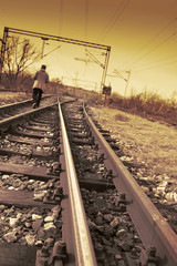 Fototapeta na wymiar Young man walking on rail road