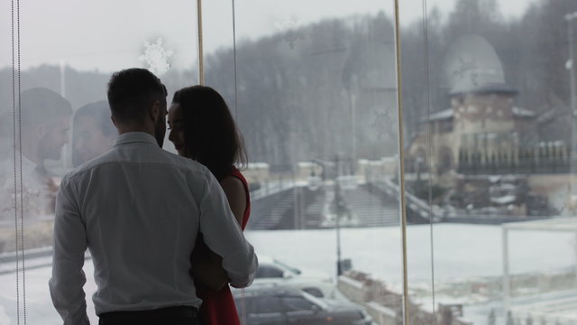 Young couple is standing near the window 