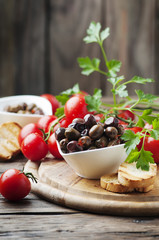 Olive with tamato and parsley on the wooden table