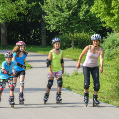 gutgelaunte Familie beim Inline-Ausflug in den Park