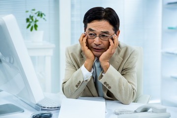 Tired businessman holding his head