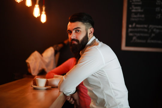 Young business man behind the bar with coffee