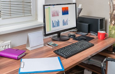 Spreadsheet processor and charts on computer in office.