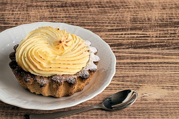  Cake.   Cake on a white dessert plate on a brown wooden background.
