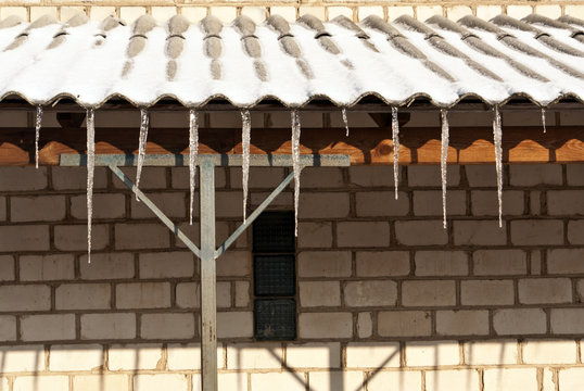 Icicles on the roof of brick house.