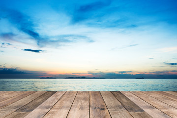 Fototapeta na wymiar Perspective of wood terrace against beautiful seascape at sunset