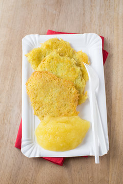Potato pancakes with apple sauce served on paper plate for take away