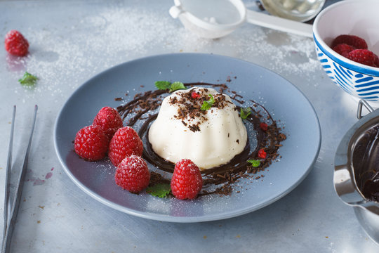 Vanilla panna cotta with chocolate sauce and fresh raspberries