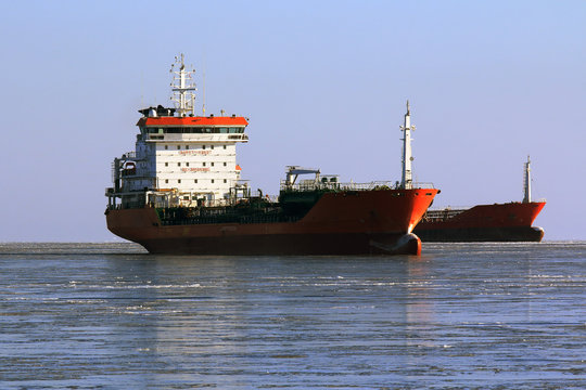 tankers at anchor in the freezing sea waiting for the loading