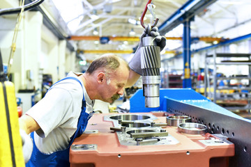 älterer Arbeiter bei der Montage von einem Getriebe in einer Fabrik // Workers in mechanical...