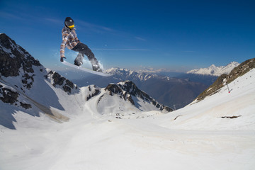 Flying snowboarder on mountains. Extreme sport.