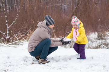 Fototapeta na wymiar Dad and daughter are playing with snow