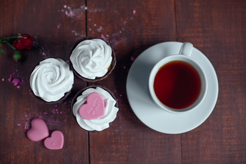 Cup of tea with valentine cupcakes .top view