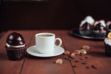 Chocolate cupcake and cup of coffee on wooden table