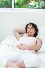 Obraz na płótnie Canvas Pregnant woman resting on her bed