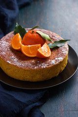 tangerine and almond cake on dark blue background,