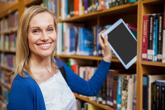 Female Student Tidying A Tablet In A Bookshelf