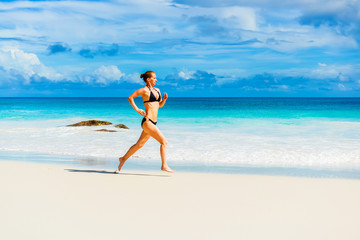 Fototapeta na wymiar Woman runs on the beach