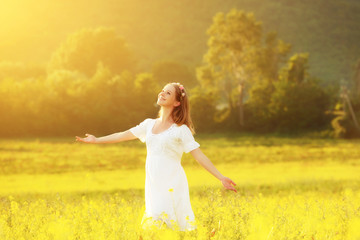 Fototapeta na wymiar Happy woman enjoying summer meadow of yellow flowers