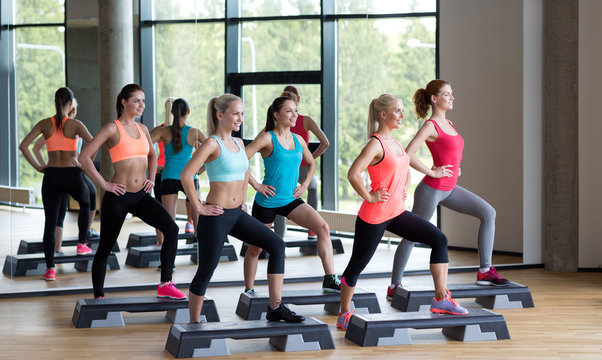 group of women working out with steppers in gym