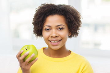 happy african american woman with green apple