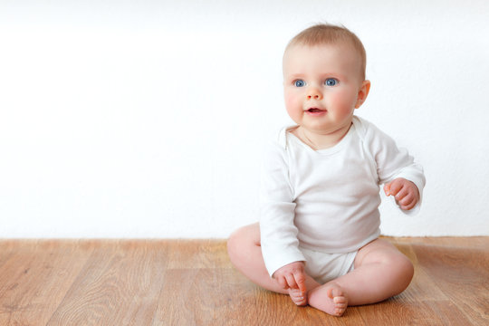 beautiful little baby on wooden floor
