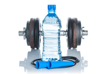 Sport concept with water bottle, jump rope and dumbbell